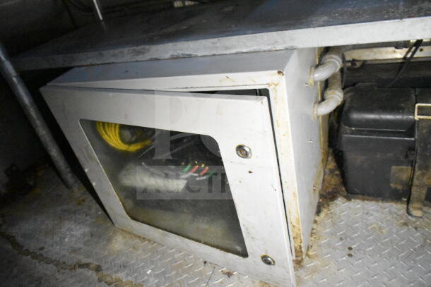 2020 LGS TX food trailer interior showing a metal cabinet with transparent door, pipes, and visible wiring.