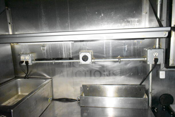 2020 LGS TX 8.5'x24' food trailer interior with outlets, metal surface, and container. Includes CaptiveAire system.