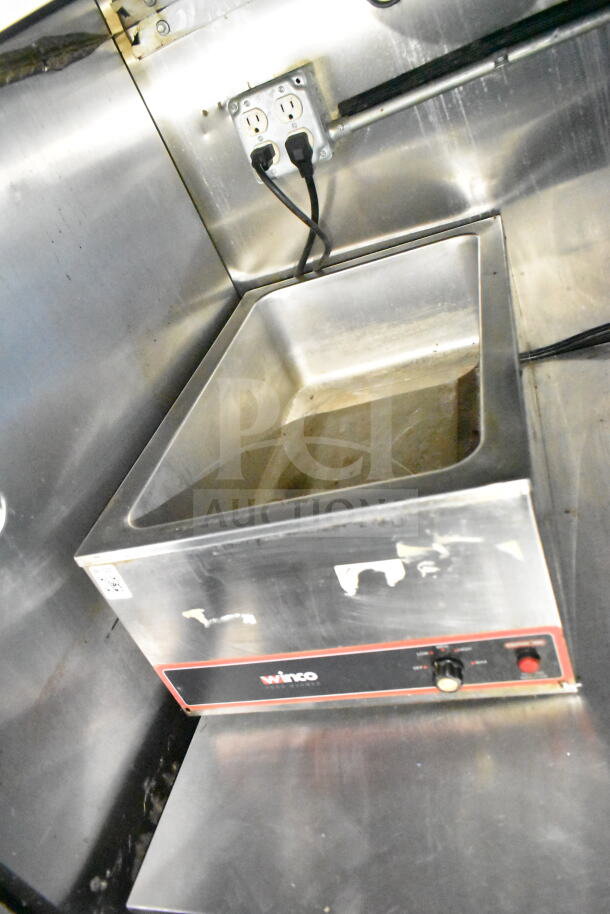 Stainless steel food tray with Winco brand label, knob control, and power outlets, inside a 2020 LGS TX food trailer.