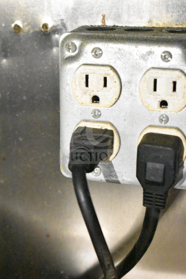 Electrical outlet inside 2020 LGS TX 8.5'x24' food trailer, showing two black power cords plugged in.