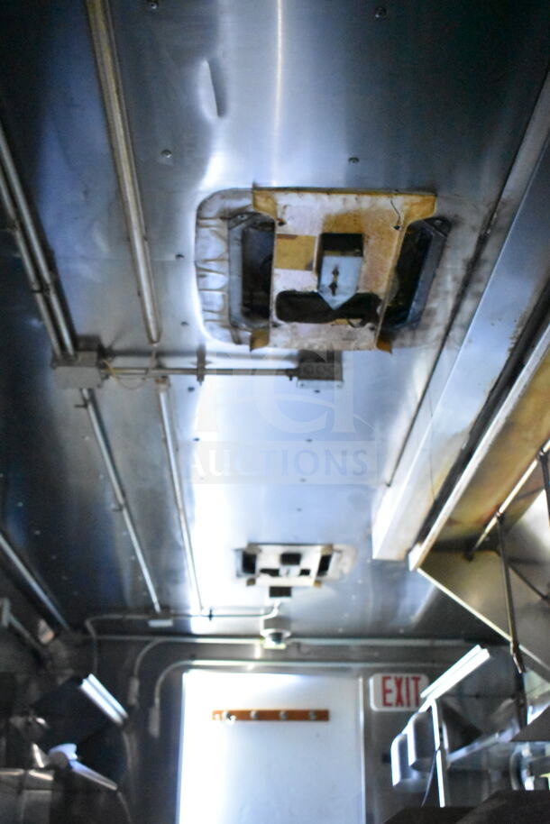 Interior of a 2020 LGS TX 8.5'x24' food trailer showing CaptiveAire grease hood. Features ducts, wiring, and lighting fixtures.