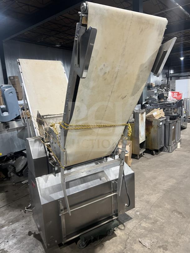 "Nice Moline floor style heavy-duty commercial reversible conveyorized dough sheeter with foot pedal, used condition."