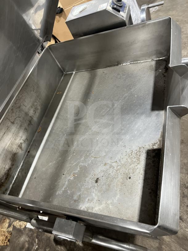 Commercial stainless steel braising pan on legs, tilting mechanism, used condition with visible wear and control panel.