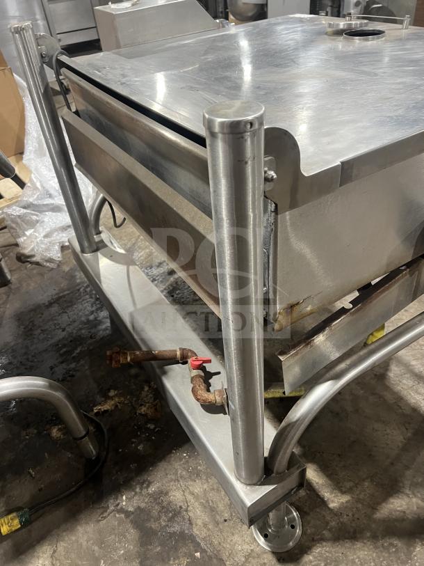 Commercial stainless steel braising pan with tilting skillet on legs, good condition, features visible plumbing connections.