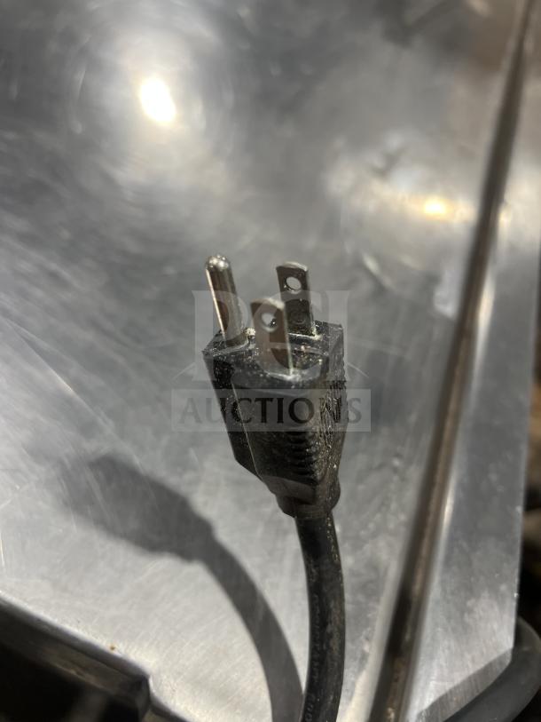 Alt text: Commercial stainless steel tilting skillet with legs, showing power plug.