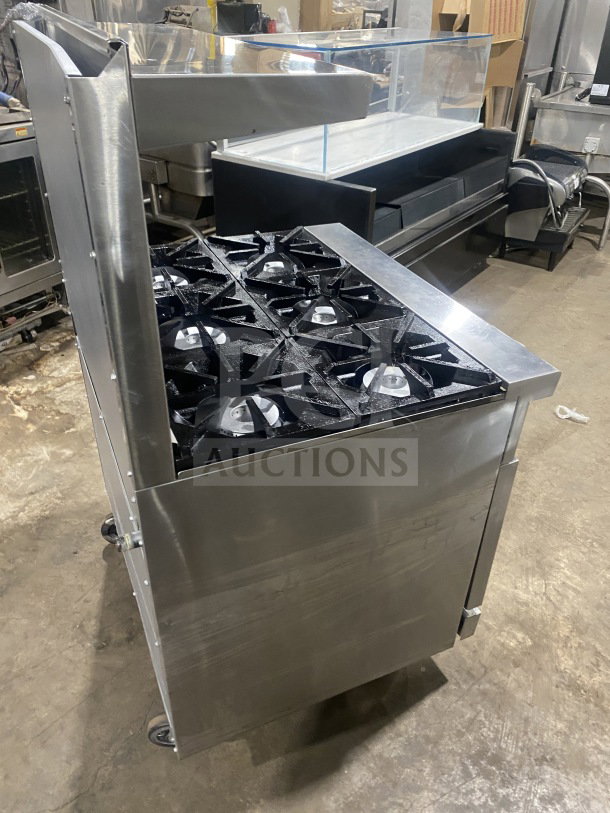 CookRite stainless steel 6-burner gas range with oven, backsplash, overhead salamander shelf, wired oven rack, and casters.