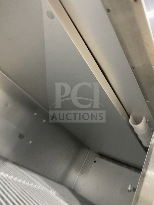 Traulsen G22010 stainless steel 2-door reach-in refrigerator interior, featuring a poly-coated wire rack, on casters.