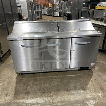 Kool-It KSP72 3-door stainless steel refrigerated prep table with cutting board, poly-coated wire rack, on casters.