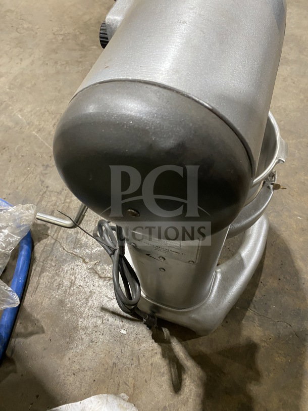 Hobart C100 commercial planetary mixer with paddle and stainless steel bowl, shown from above. Model number plate visible.