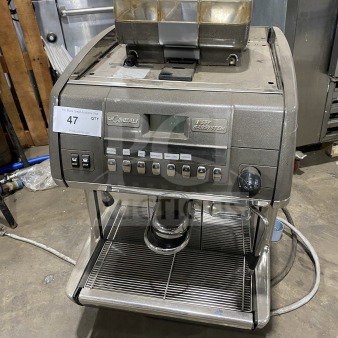 Rare La Cimbali commercial automatic espresso machine. Features stainless steel body, clear polycarbonate hopper, steam wand, and legs.