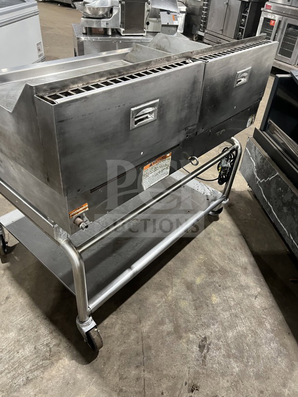 Commercial stainless steel heavy-duty flat-top griddle with two sections, back and side splash, on casters. Good condition.