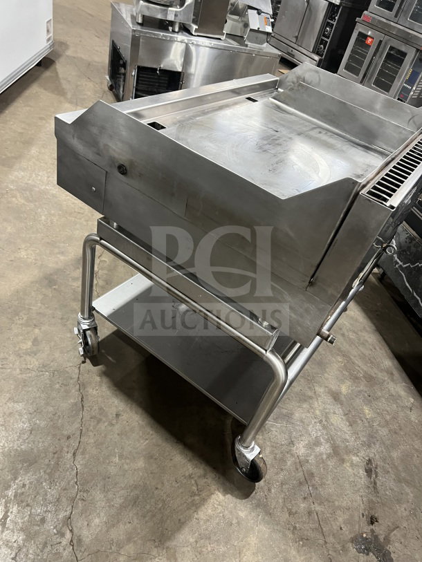 Commercial stainless steel heavy-duty flat-top griddle with two sections, back and side splash. Mounted on casters for mobility.