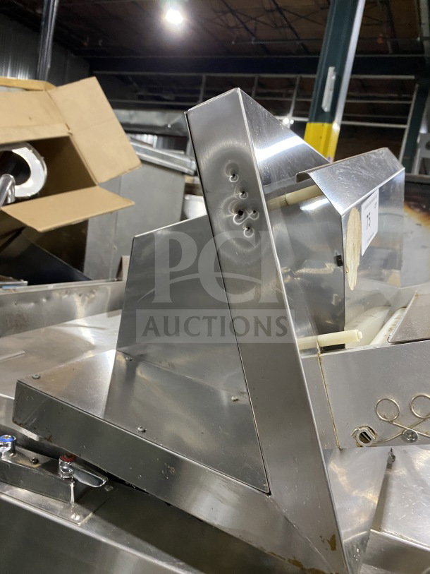 Omcan M42A stainless steel food packaging machine, electric, heavy-duty, model SN: 0195860, 110V, in warehouse setting.