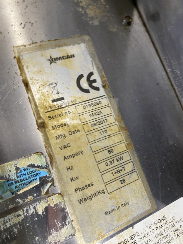 Omcan M42A commercial stainless steel food packaging machine, serial 0195860, 110V, visible wear on label, made in Italy.