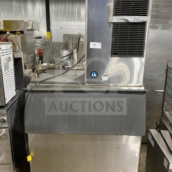 Hoshizaki commercial stainless steel cube ice making machine with storage bin, electric powered, on legs, model tag visible.
