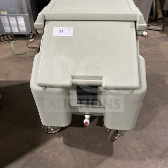 Cambro commercial insulated ice bin on casters, beige, with drain spout and Cambro logo, in good condition. Tag number 83 visible.