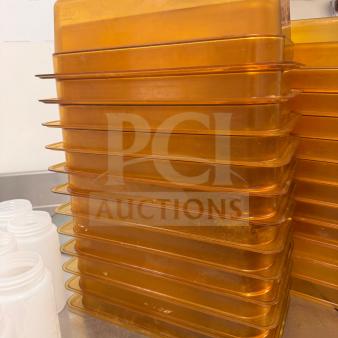 Stack of amber food storage pans, durable and high-quality, showing slight wear, ideal for kitchen use.