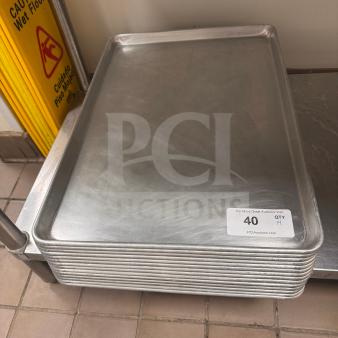 Stack of aluminum baking sheets in good condition, quantity 14. Label shows auction lot information.