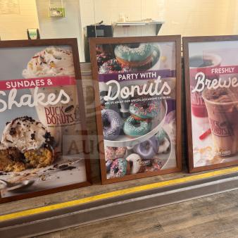 Set of 3 framed Duck Donuts posters featuring sundaes, donuts, and iced coffee. Excellent condition, vibrant colors.