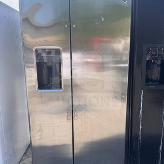 Stainless steel GE side-by-side refrigerator with water and ice dispenser, used, minor cosmetic wear, missing handles.