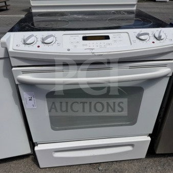 GE residential electric range oven with glass cooktop, used condition, visible wear, white color, control knobs present.