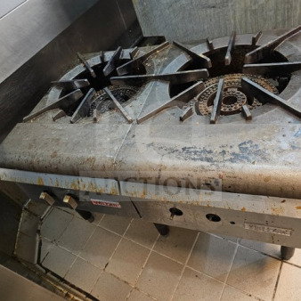 Commercial two-burner gas stock pot range, used condition with visible grease and residue on burners and surfaces.