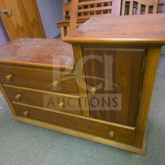 Wooden dresser with three drawers and a cabinet, medium finish. Noticeable wear and scratches on top surface. Solid condition.