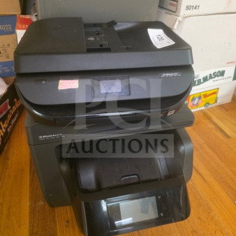 Lot of two black multifunction printers, featuring touchscreens and control panels. Some wear visible. Includes tags and stickers.
