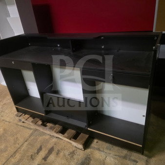 Black retail cashier checkout counter featuring multiple shelves and compartments. Visible scratches on the surface.