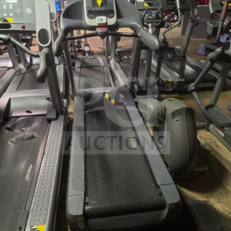 Precor commercial grade treadmill, unknown working condition, sold as is. Black frame, digital display, gym setting.