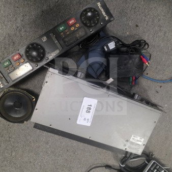 Lot of miscellaneous electronics including Numark audio mixer, speaker, and assorted cables. Condition varies.