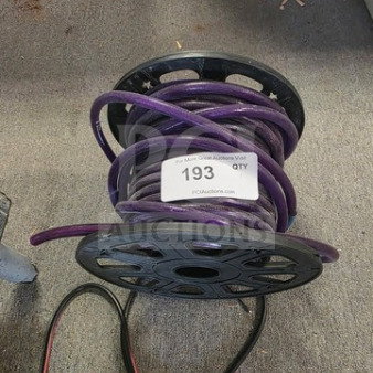 Spool of purple rope light on black reel, used condition, auction tag labeled "193".
