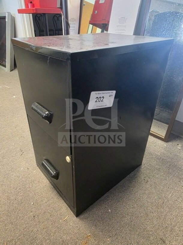 Black two-drawer filing cabinet, metal, used condition, some surface scratches. Label reads "202".