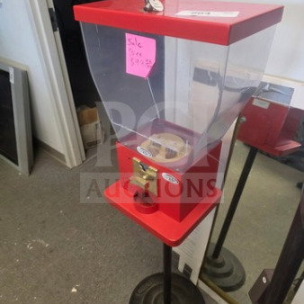 Red gumball machine on stand, clear acrylic globe, secure lock, in used condition, sale price tag $99.99.