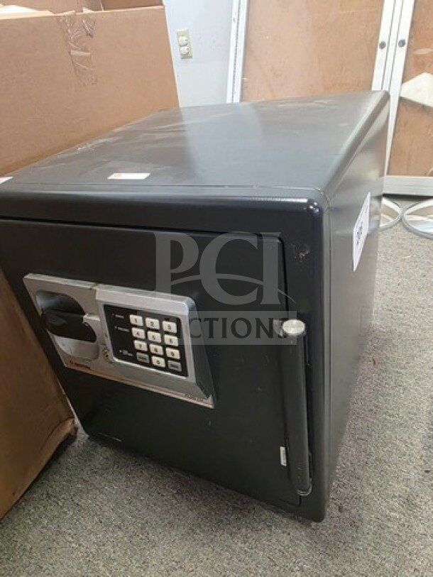 Black safe box with electronic keypad, no known combination. Rectangular shape, minor wear, sturdy handle, and side locking bolt.
