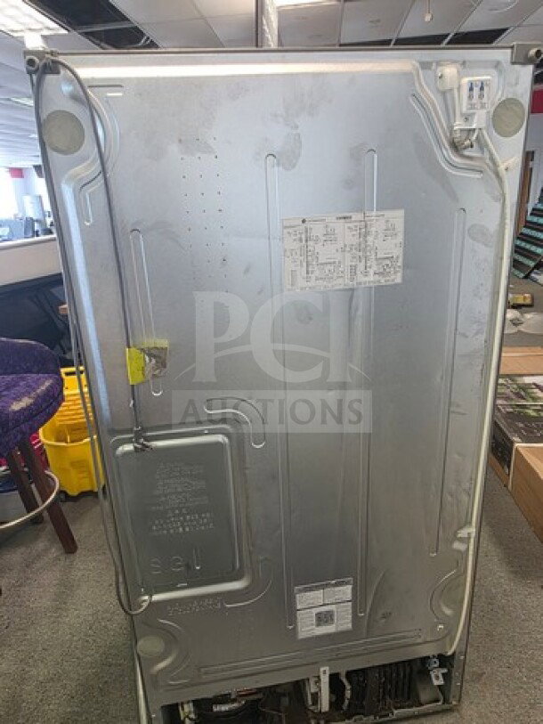 Stainless Steel LG French Door Refrigerator, unknown working condition, sold as is. Back view shows model tag and serial number markings.