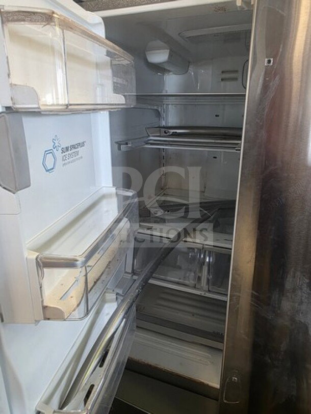 Stainless Steel LG French Door Refrigerator, interior view. Visible shelves, unknown working condition, sold as is.