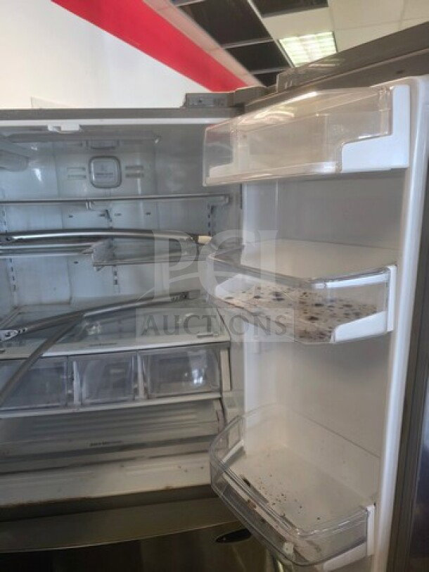 Stainless steel LG French door refrigerator, internal view. Unknown working condition. Sold as is, signs of wear visible.