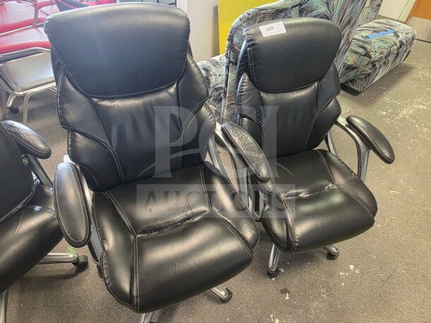 Lot of 4 black leather office chairs with padded armrests, chrome legs, and visible wear. Label marked "209".