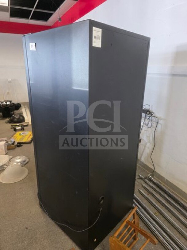 Black vending machine, condition unknown, sold as is. Appears functional, no visible brand or model markings.