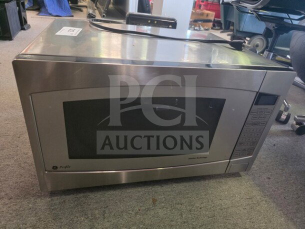 Stainless steel GE Profile microwave, keypad control, sold as is. Unknown working condition, visible wear on surface.