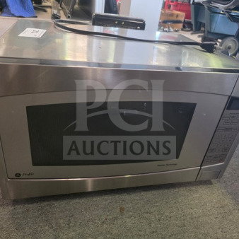 Stainless steel GE Profile microwave, keypad control, sold as is. Unknown working condition, visible wear on surface.
