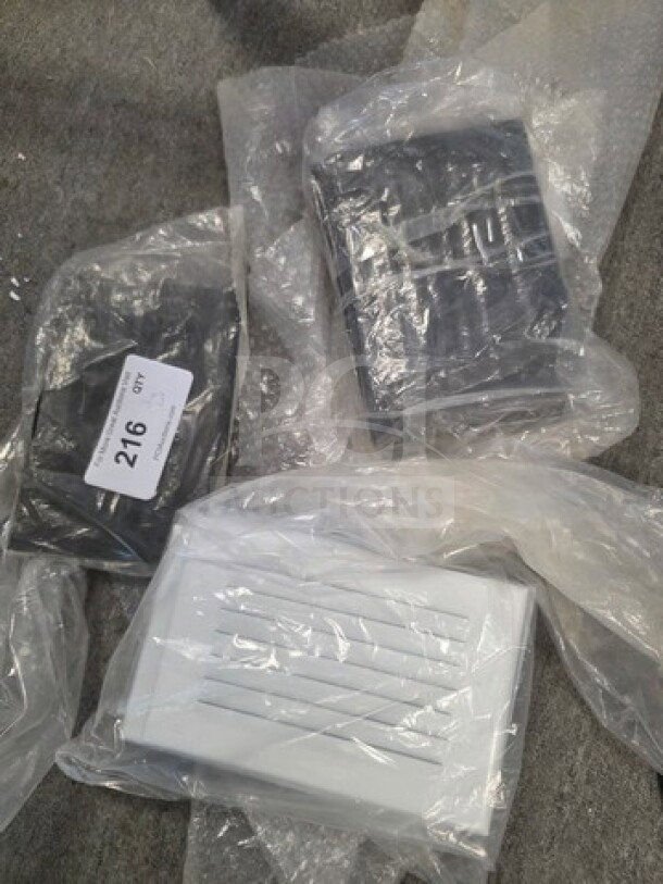Lot of new faceplate covers in plastic wrap, includes black and white varieties. Visible label with number 216.