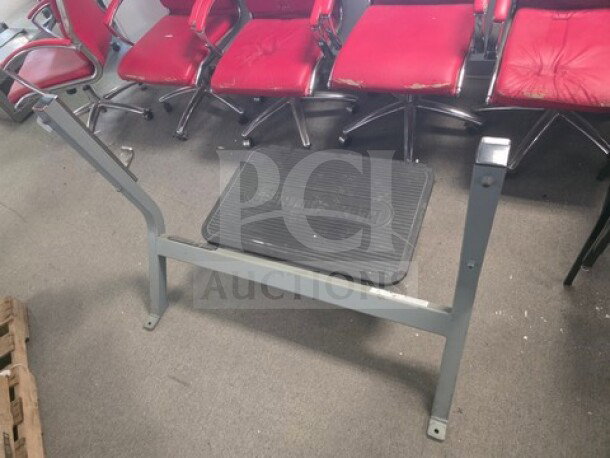 Heavy-duty deadlift platform with non-slip surface, sturdy metal frame, used condition with visible wear.
