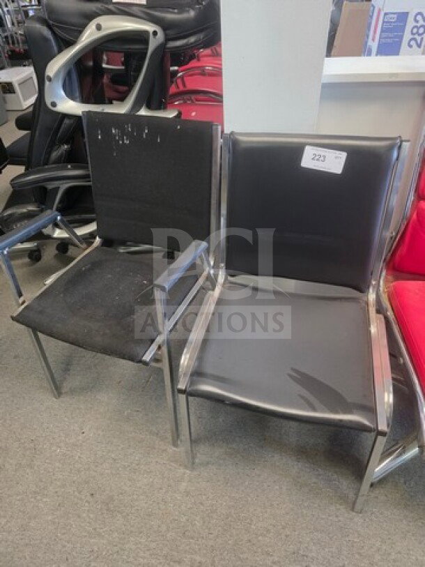 Lot of 2 office chairs with metal frames and black cushions; visible wear and specific tag numbered 223 on one chair.