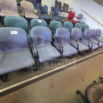 Lot of 7 office chairs with blue fabric upholstery, black armrests, and metal frames. Used condition, visible numbering tags.