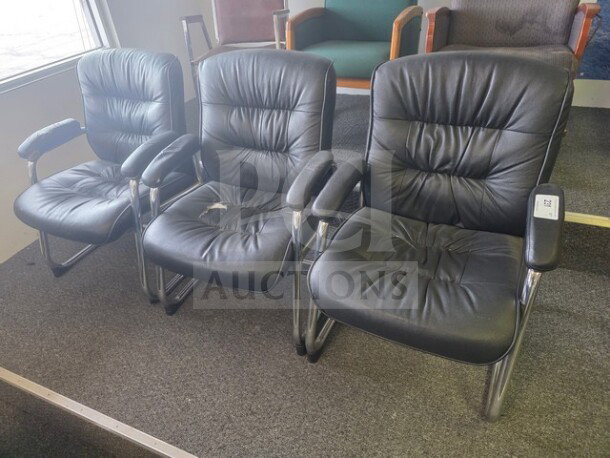 Lot of 3 black office chairs with chrome frames. Cushioned seats show signs of wear. One chair has a visible tear.