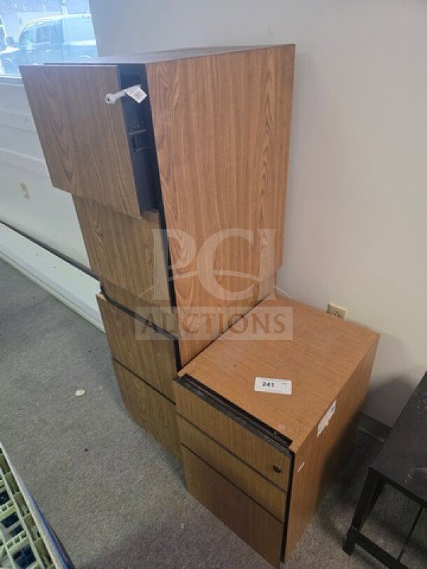 Lot of 3 wooden filing cabinets, stacked arrangement, light brown finish, varying sizes, visible labels, some wear.