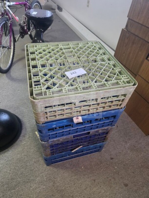 One lot of glassware/dishware racks, stackable, mixed colors, used condition, tag with lot number 242, suitable for storage.