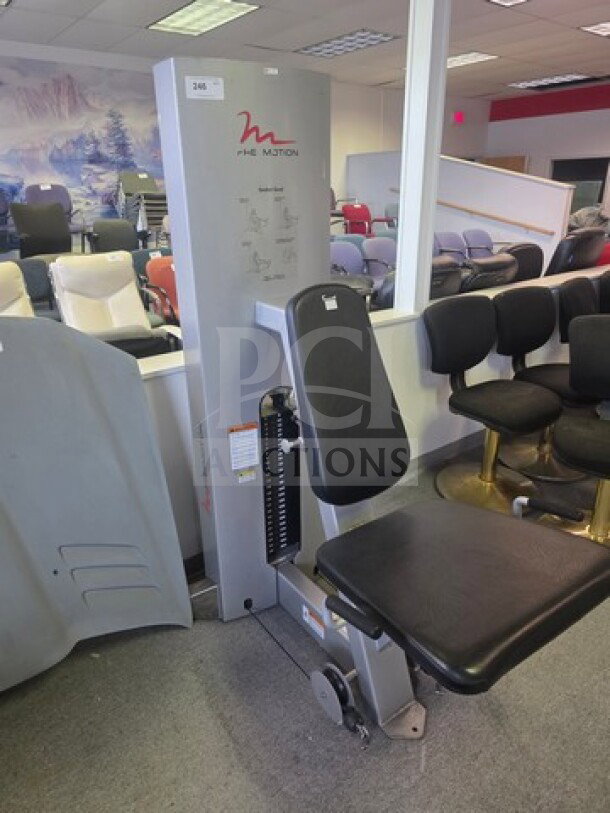 FreeMotion seated exercise machine, features padded seat and backrest, in good condition, with visible weight stack and instructions.